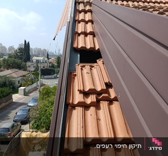 גג רעפים עם נוף עירוני ברקע